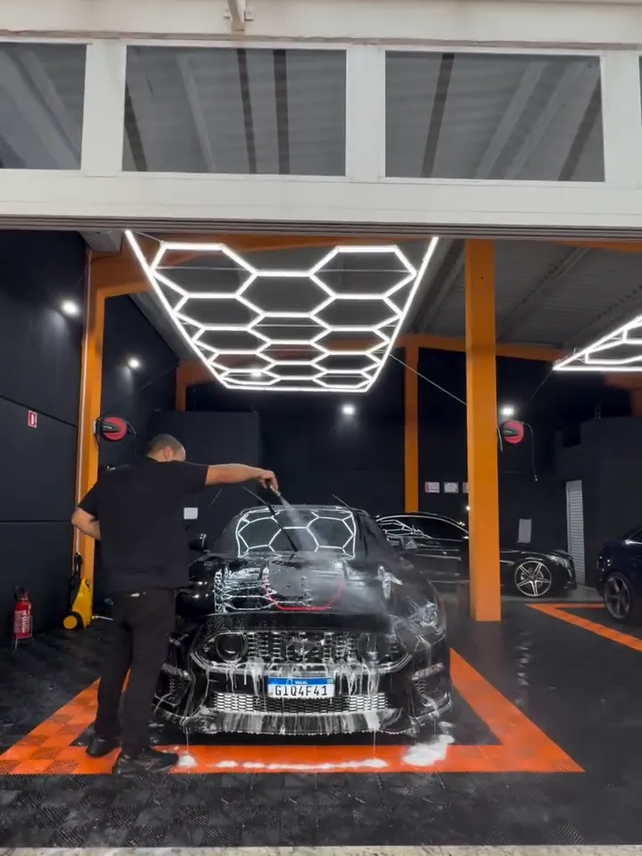 Box da Vision Studio com a iluminação hexagonal em LED e um carro sendo lavado